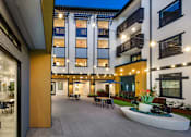 Thumbnail 81 of 94 - A modern building with a courtyard and a fountain.