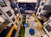 Thumbnail 77 of 94 - A courtyard with a blue umbrella and lights on the ground.