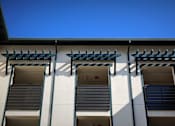 Thumbnail 84 of 94 - Three windows with black shutters on a white building.