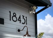 Thumbnail 69 of 94 - A house numbered 18431 is shown with a security camera and a light fixture.