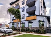 Thumbnail 60 of 94 - A modern two-story house with a car parked in front.