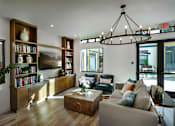 Thumbnail 57 of 94 - A living room with a large bookshelf and a chandelier.