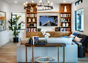 Thumbnail 65 of 94 - A living room with a white couch, a coffee table, and a bookshelf.