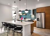 Thumbnail 42 of 94 - A kitchen with a white countertop and black chairs.