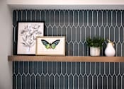 Thumbnail 44 of 94 - A shelf with a picture of a butterfly, a plant, and a vase.