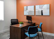 Thumbnail 48 of 94 - A modern office with a wooden desk and blue chair.