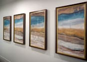 Thumbnail 40 of 94 - Four paintings of beach scenes are lined up on a wall.