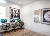 Thumbnail 39 of 94 - A room with a desk, chairs, and artwork on the wall.