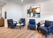 Thumbnail 36 of 94 - A room with four blue chairs and a painting on the wall.