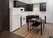 Thumbnail 21 of 94 - A modern kitchen with a white refrigerator and black cabinets.