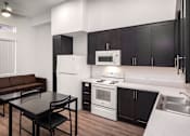 Thumbnail 20 of 94 - A modern kitchen with black cabinets and a white fridge.