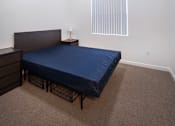 Thumbnail 25 of 94 - A bedroom with a bed, nightstand, and window.