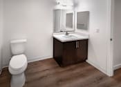 Thumbnail 24 of 94 - A white toilet sits next to a sink in a small bathroom.