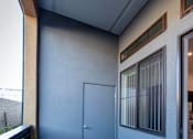 Thumbnail 34 of 94 - A room with a grey floor and a grey wall with a door and a window.