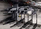 Thumbnail 31 of 94 - A parking garage with a row of black bikes on the racks.