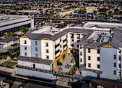 Thumbnail 10 of 94 - A white building with a yellow awning is in the foreground of a cityscape.