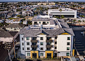 Thumbnail 6 of 94 - A large white building with a yellow section in the middle of it.