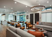 Thumbnail 77 of 90 - A modern living room with a grey sofa and orange pillows.