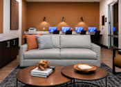 Thumbnail 78 of 90 - A modern living room with a grey sofa, a coffee table, and a large circular light fixture on the ceiling.