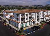 Thumbnail 64 of 90 - A parking lot in front of a white building with a red roof.