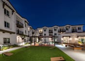 Thumbnail 71 of 90 - A well-lit outdoor area of a residential building at night.