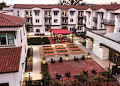 Thumbnail 35 of 90 - A courtyard with a red roof and a white building with balconies.