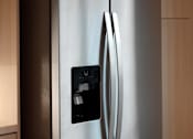 Thumbnail 51 of 90 - A stainless steel refrigerator with a black control panel on the door.