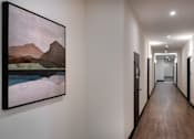 Thumbnail 42 of 90 - A long hallway with a painting on the wall.