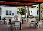 Thumbnail 40 of 90 - A patio with a table and chairs under a red canopy.