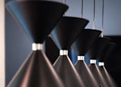Thumbnail 46 of 90 - A series of black pendant lights are suspended from the ceiling.