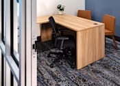Thumbnail 33 of 90 - A room with a desk and chairs.