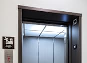 Thumbnail 54 of 90 - A black door with a sign on the wall to the left of the door.