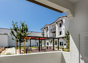 Thumbnail 10 of 90 - A white building with a balcony overlooking a courtyard.
