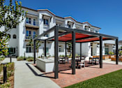 Thumbnail 2 of 90 - A modern building with a white exterior and a red awning.