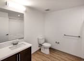 Thumbnail 30 of 90 - A white bathroom with a toilet, sink, and mirror.