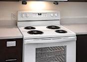 Thumbnail 24 of 90 - A white stove and microwave in a kitchen.