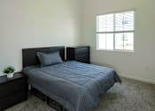 Thumbnail 13 of 90 - A bedroom with a bed, nightstand, and window.