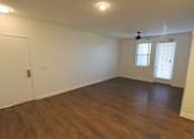 Thumbnail 25 of 25 - A room with a ceiling fan and wooden flooring.