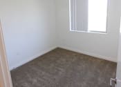 Thumbnail 23 of 25 - A room with a carpeted floor and a window.
