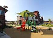 Thumbnail 17 of 25 - A playground with a green umbrella and a red slide.