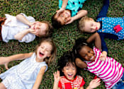 Thumbnail 12 of 21 - A group of children lying on the grass.