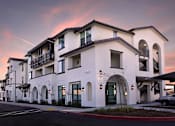 Thumbnail 33 of 61 - A row of white buildings with balconies and arched windows.
