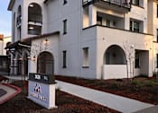 Thumbnail 34 of 61 - A modern two-story building with a balcony on the second floor.