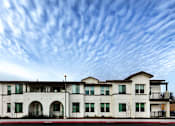 Thumbnail 26 of 61 - A white two story house with a balcony on the second floor.
