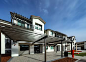 Thumbnail 10 of 61 - A modern house with a white and grey exterior and a black roof.