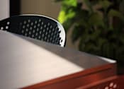 Thumbnail 61 of 61 - A red chair with a perforated back sits in front of a table.