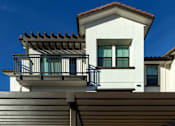 Thumbnail 43 of 61 - A modern house with a balcony and a covered entrance.