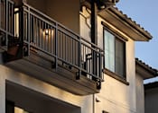 Thumbnail 38 of 61 - A balcony with a railing and lights is on the second floor of a building.