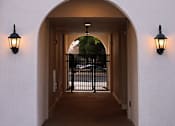 Thumbnail 59 of 61 - A white building with a black gate in the middle of a passage.