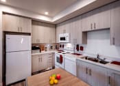 Thumbnail 40 of 61 - A modern kitchen with a white refrigerator, microwave, and oven.
